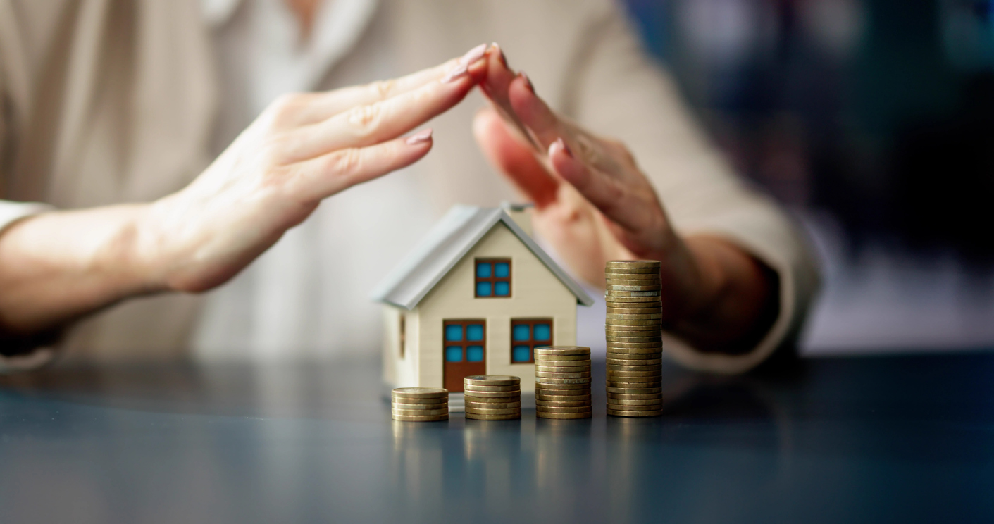 Haus und Geld wird von einer Hand geschützt