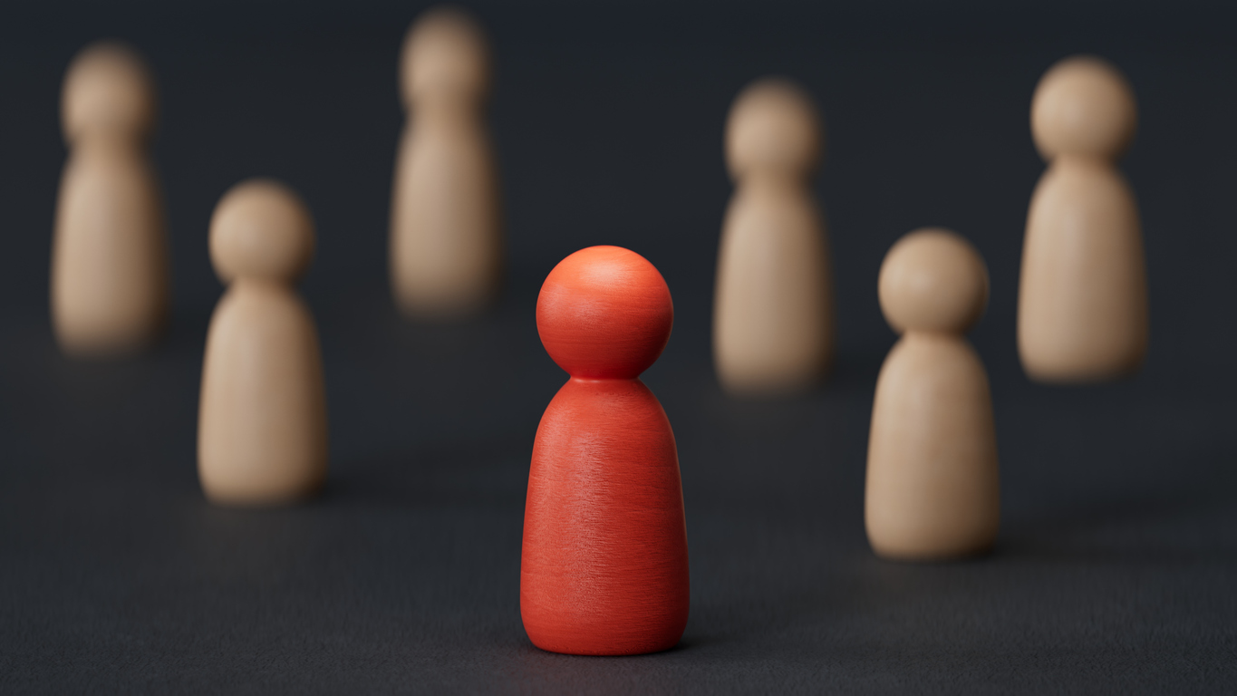 Spielfiguren im Vordergrund eine rote einzelne Spielfigur